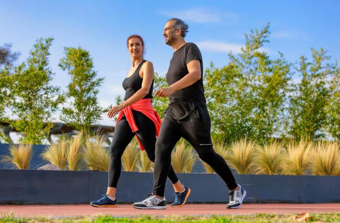 A man and woman walking around a track